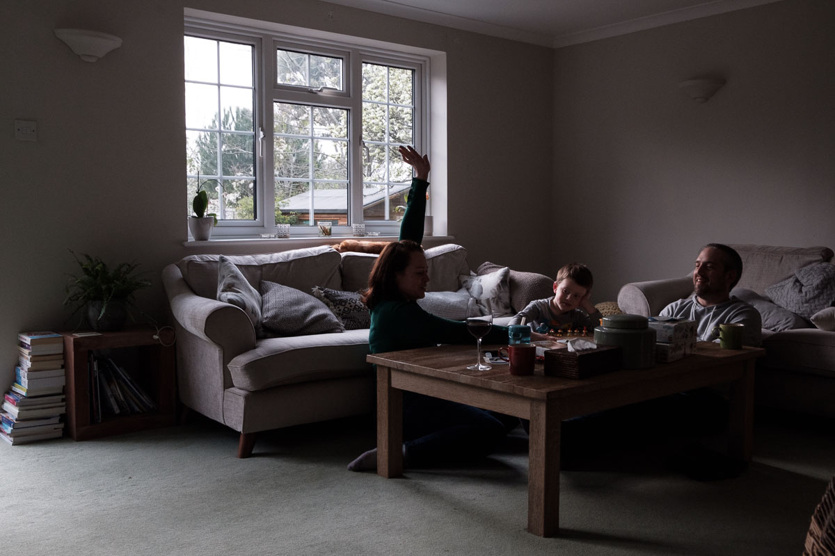 Scene with family playing a boardgames in the living room.