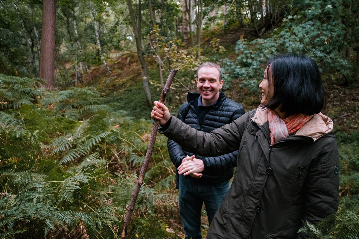 Man and woman smiling at each other in a forest
