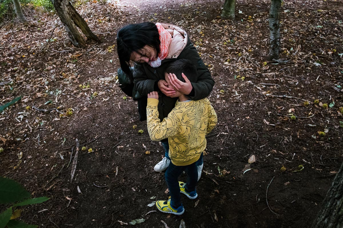 mother cleaning son's face in woods