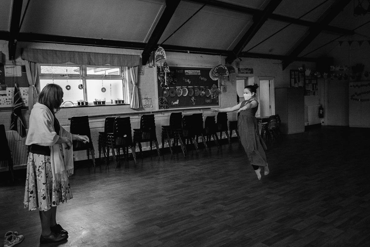 girl dancing in large room with woman watching